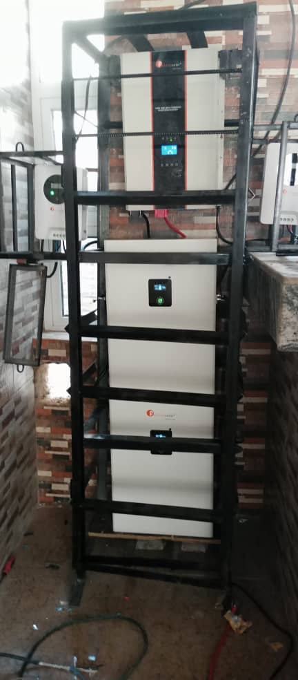 Stacked lithium battery bank with hybrid inverter on a mounting rack